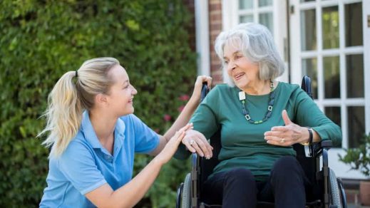 Nurse talking to an old lady sitting on wheelchair — Disability Support in Wollongong, NSW